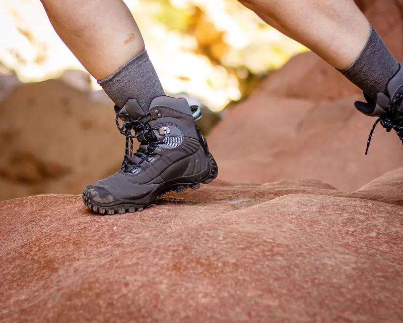 Close-up of hiking boots on a rocky trail, emphasizing outdoor adventure