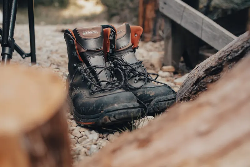 Close-up of durable hiking boots on rocky ground, ideal for outdoor adventures