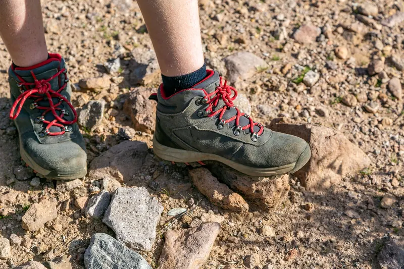 Close-up of hiking boots on rocky ground in Arizona's desert landscape