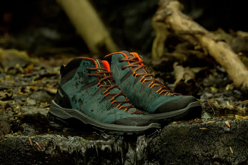 Teal hiking boots with orange laces in natural riverbed setting in England