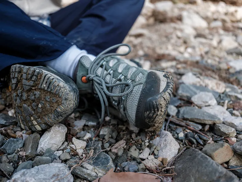 Mud-speckled hiking boots on a rocky trail, representing adventure and exploration